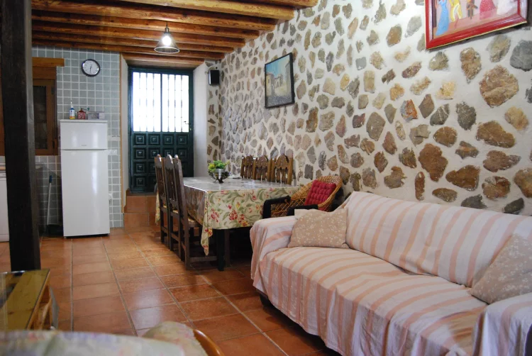 Salón-comedor con pared de piedra en Arroyo Milano
