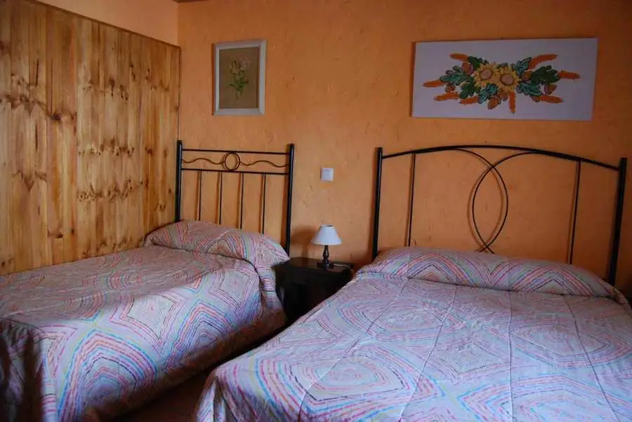 Dormitorio doble naranja en alojamiento rural Maello