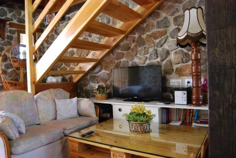 Zona de estar con TV en casa rural Arroyo Milano